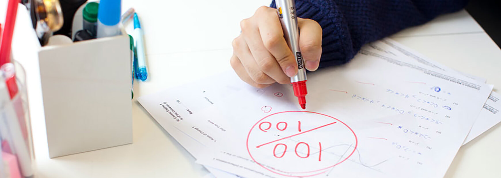matrix education student writing on paper with a red pen