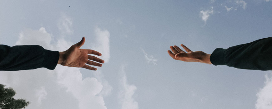 image of two hands reaching for one another shot from below how-to-write-a-year-6-extended-response-in-6-steps