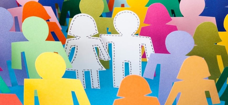 picture of a crowd of brightly coloured paper cutout people surrounding a pair of blank paper cutout people literary techniques character archetypes figure out which archetype fits the character