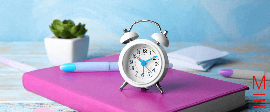 Alarm clock on a pink book