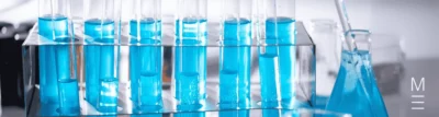 Test tubes filled with blue liquid arranged in a rack in a laboratory