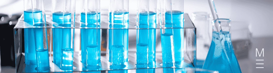 Test tubes filled with blue liquid arranged in a rack in a laboratory