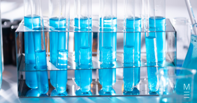 Test tubes filled with blue liquid arranged in a rack in a laboratory