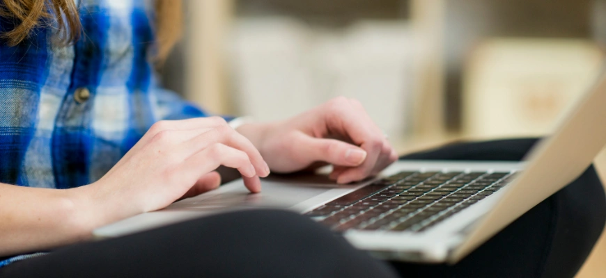 Close-up of hands typing on a laptop