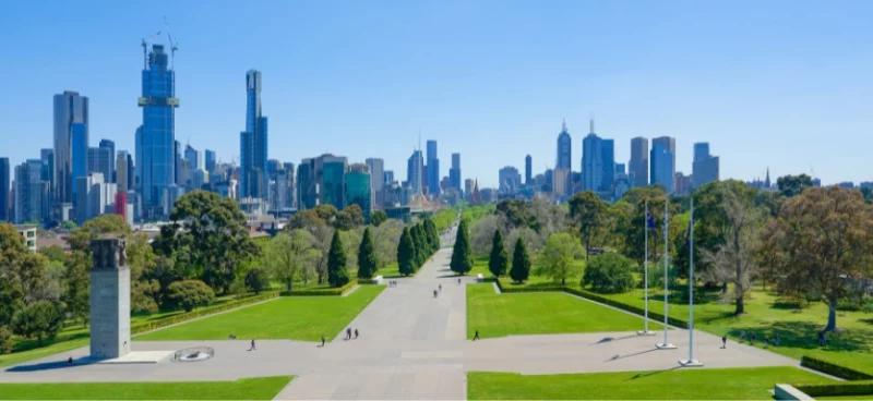 View of a Melbourne city skyline with green lawns in the foreground