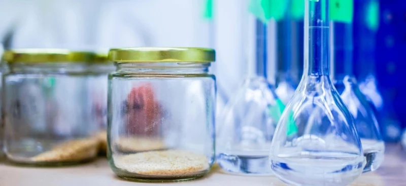 Glass jars and lab flasks on a chemistry lab table