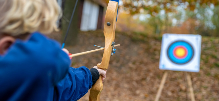 child aiming arrow target 