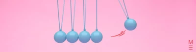 matrix education Newton's cradle with blue spheres against a pink background, symbolising motion from the Physics VCE exam