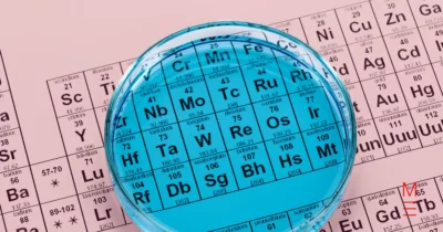 Close-up of the periodic table viewed through a blue-tinted Petri dish