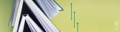 Open books with teal arrows on a green background, symbolising progress.