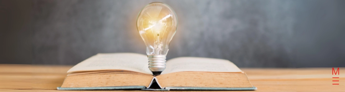 Lightbulb glowing on an open book