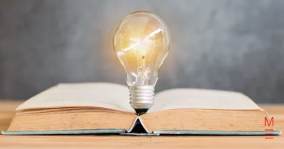 Lightbulb glowing on an open book