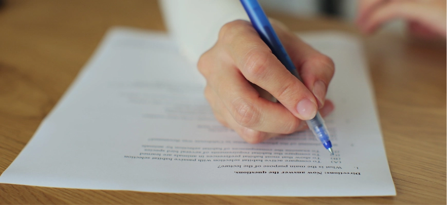 Hand writing on a printed document with a blue pen