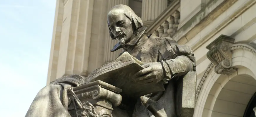 Statue of Shakespeare reading a book