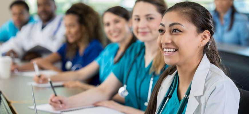 Group of medical students in a classroom setting, smiling=