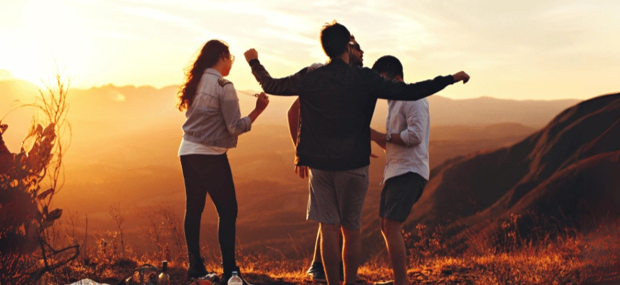 Group of friends enjoying a sunset on a mountain