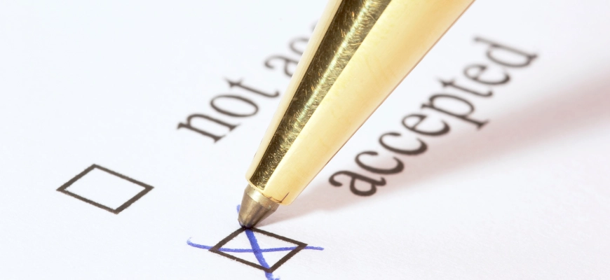 Close-up of a pen ticking 'accepted' on a form