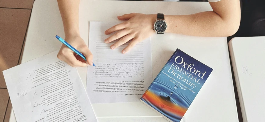 student answering an english worksheet with an Oxford dictionary next to him