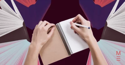 Hands writing in a notebook surrounded by open books, symbolising study for VCE English essays