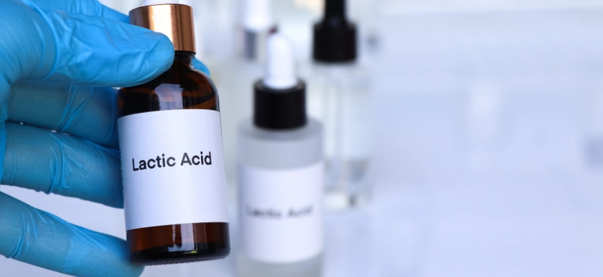 matrix education Close-up of a labeled vial of lactic acid held by a gloved hand, in a lab