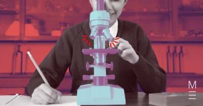 Student using a microscope in a biology lab, adjusting the focus while taking notes