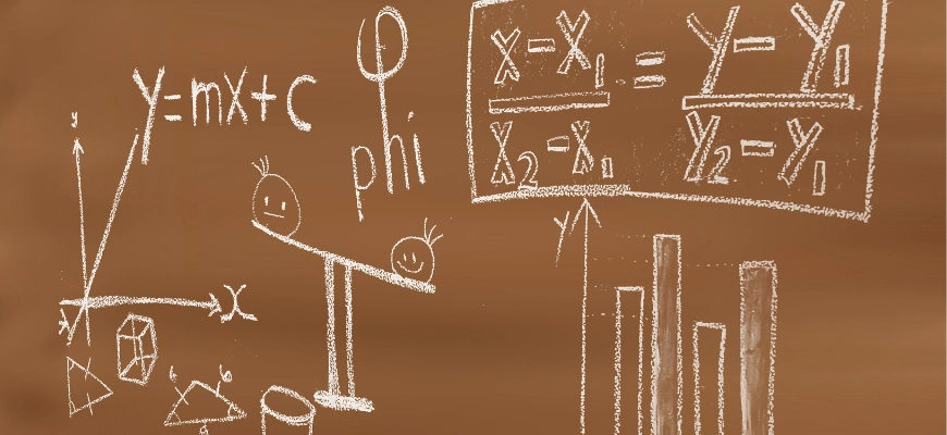 A chalkboard with various mathematical equations, graphs, and shapes drawn