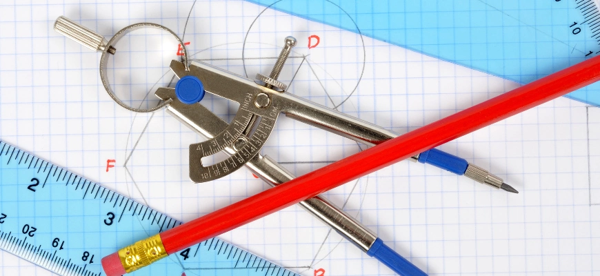 A geometry compass and ruler placed on graph paper with circles and angles drawn, symbolising key maths skills in year 7 