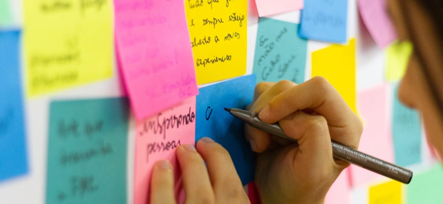 matrix education a person writing on a blue sticky note, surrounded by colorful sticky notes